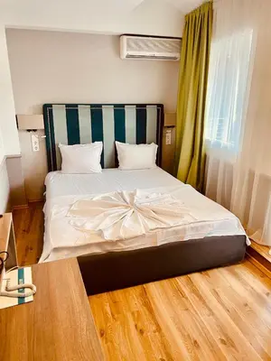 a bedroom with a large bed with white sheets at BSA Boulevard Boutique in Sunny Beach