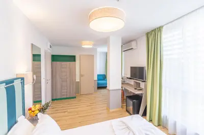 a hotel room with a bed and a living room at BSA Boulevard Boutique in Sunny Beach