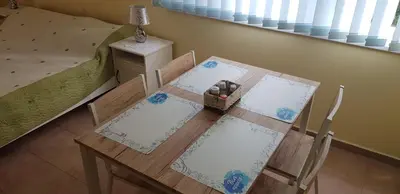 a dining room table with two chairs and a bed at Słoneczny Brzeg Green Fort Noks Studio in Sunny Beach