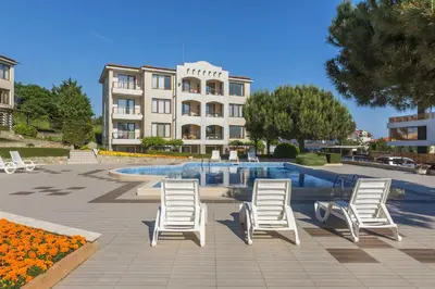 a group of chairs and a swimming pool with a building at View Apartments in Sozopol