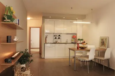 a kitchen with white cabinets and a table with chairs at View Apartments in Sozopol