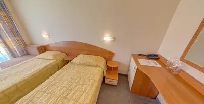 a small room with two beds and a desk at Hotel Pliska - All Inclusive Light in Sunny Beach