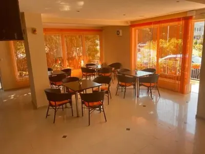 a dining room with tables and chairs and windows at Hotel Paradise in Lozenets