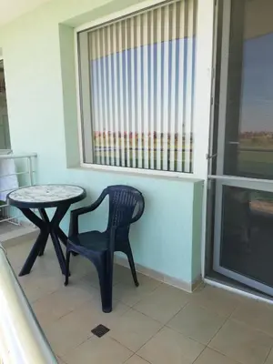 a table and a chair in a room with a window at DEA Pasavan Apartments in Ravda