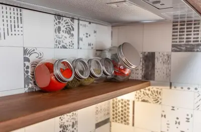 a row of jars on a shelf in a kitchen at Pomorie Seaside Apartments in Pomorie