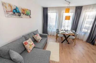 a living room with a gray couch and a table at Pomorie Seaside Apartments in Pomorie
