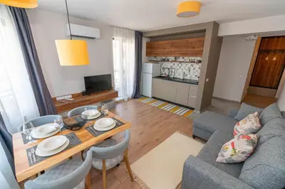 a living room with a table and a couch at Pomorie Seaside Apartments in Pomorie