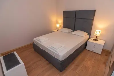a bedroom with a large bed with two lamps at Pomorie Seaside Apartments in Pomorie