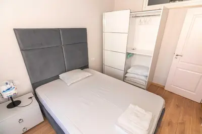 a small bedroom with a bed and a closet at Pomorie Seaside Apartments in Pomorie