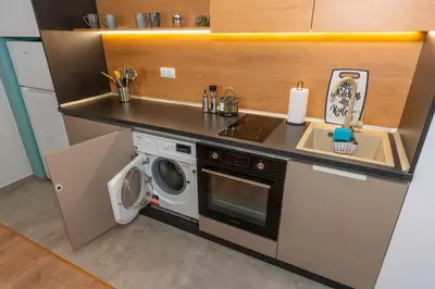a kitchen with a sink and a washing machine at Pomorie Seaside Apartments in Pomorie