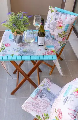 a table with a bottle of wine and two chairs at Pomorie Seaside Apartments in Pomorie