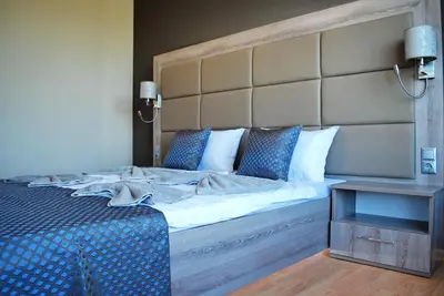 a bedroom with a large bed with a large headboard at Dune Boutique Pomorie in Pomorie