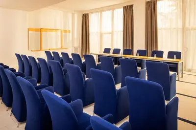 a conference room with blue chairs and a table at AluaSoul Sunny Beach - Adults Only - All Inclusive in Sunny Beach