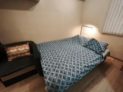 a bedroom with a bed and a lamp and a chair at Apartment in the Center 1 in Varna City