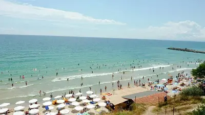 a crowd of people on a beach with umbrellas at Vista Del Mar Ap 22 in Ravda
