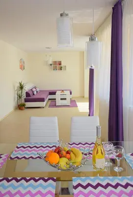 a dining room table with fruit on it with purple curtains at Rusalka Apart-Residence in Obzor