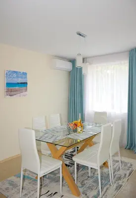 a dining room with a table and white chairs at Rusalka Apart-Residence in Obzor