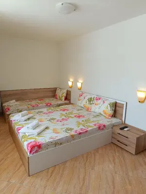 a bedroom with a bed with flowers on it at Виктория Созопол in Sozopol