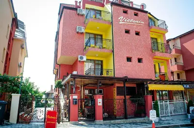 a red building with a sign on the side of it at Виктория Созопол in Sozopol