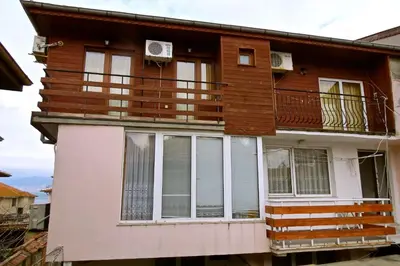 a house with a balcony withwindows and a deck at Family Hotel Lebed in Nesebar