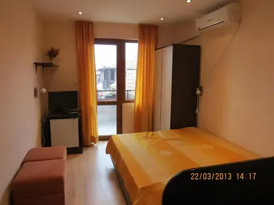 a bedroom with a bed and a television and a window at Family Hotel Lebed in Nesebar