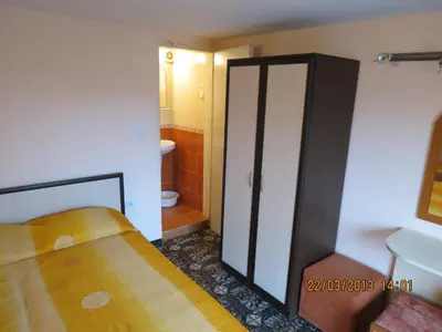 a small bedroom with a bed and a bathroom at Family Hotel Lebed in Nesebar