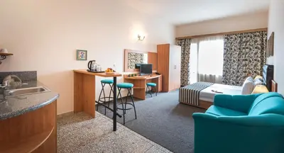 a hotel room with a bed and a kitchen and a bedroom at Lotus Family Hotel - Free Parking in Sunny Beach