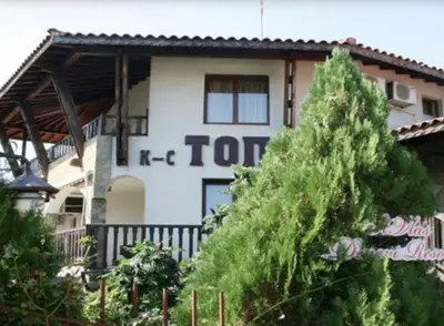 a white building with a sign on the side of it at Комплекс «ТОП» in Sveti Vlas