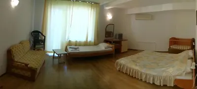 a room with two beds and a couch and a chair at Harmony Beach Family Hotel in Nesebar