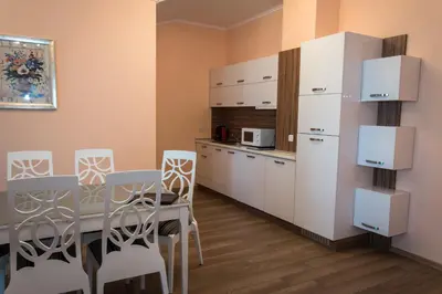 a kitchen with a table and white cabinets at Long Beach Resort in Shkorpilovtsi