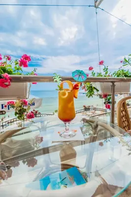 a glass table with a yellow drink on a balcony at Mirage Hotel in Nesebar