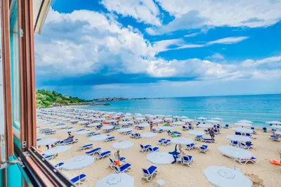 a beach with chairs and umbrellas and the ocean at Mirage Hotel in Nesebar