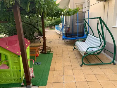 a play area with a swing and a playground at Lilia Guest House in Nesebar