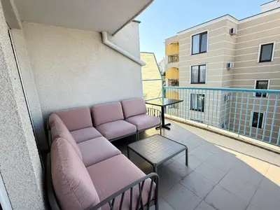 a balcony with a couch and a table on a building at Lilia Guest House in Nesebar