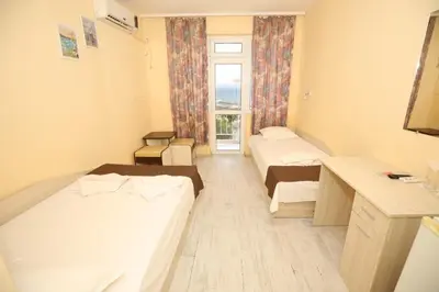 a hotel room with two beds and a window at Family Hotel White House in Pomorie