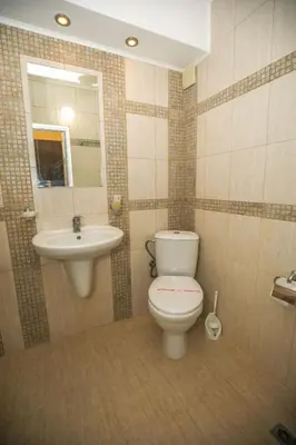 a bathroom with a toilet and a sink at Family Hotel White House in Pomorie