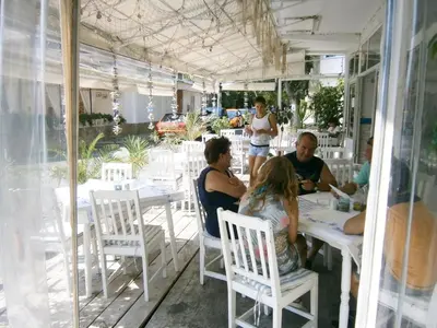 a group of people sitting at tables in a restaurant at Family Hotel White House in Pomorie