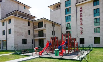 a playground in front of a large building at Amadeus Lux - Menada Apartments in Sunny Beach