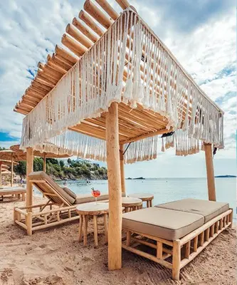 a beach with an umbrella and chairs and a table at FLORES GARDEN SEA VIEW APARTMENT WITH BALCONY in Chernomorets