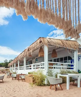 a building on the beach with chairs and tables at FLORES GARDEN SEA VIEW APARTMENT WITH BALCONY in Chernomorets