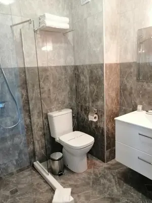 a bathroom with a toilet and a shower and a sink at Allure Beach Resort Aparthotel in Primorsko