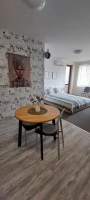 a bedroom with a bed and a table and a bed at Apartment SeaGarden 19 in Varna City