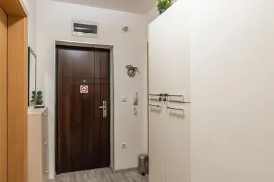 a hallway with a wooden door in a room at Apartment SeaGarden 19 in Varna City