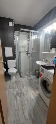 a bathroom with a shower and a toilet and a washing machine at Apartment SeaGarden 19 in Varna City