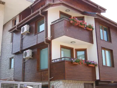 a building with a balcony with flowers on it at Dari Guest Rooms Стаи за гости Дари in Nesebar