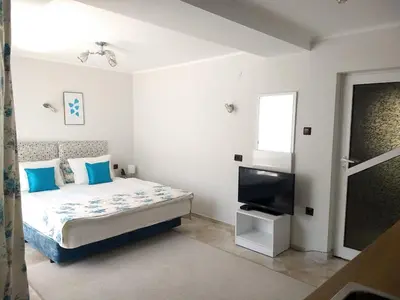 a bedroom with a bed and a flat screen tv at White Rose Guest Rooms in Burgas City