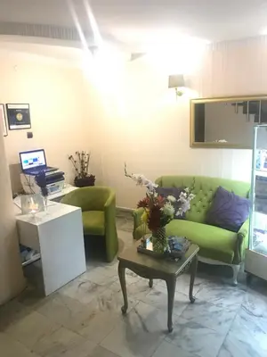 a living room with a green couch and a table at White Rose Guest Rooms in Burgas City