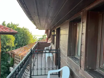 a balcony with a white chair on a building at Rony Hotel in Nesebar