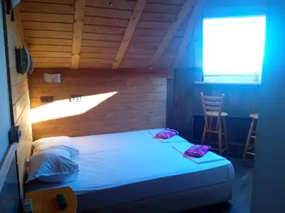 a bed in a room with a window and a chair at Rony Hotel in Nesebar