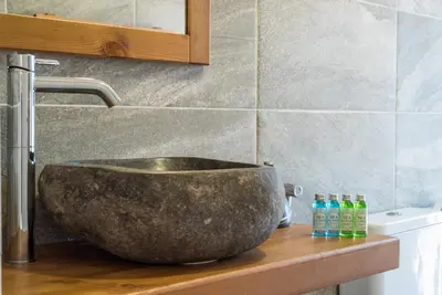 a bathroom sink with a large stone bowl on a counter at Camping Gradina in Sozopol